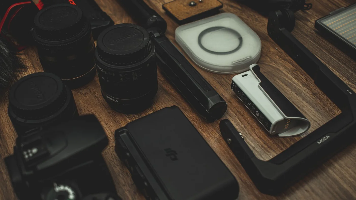 Ahşap masa üzerinde fotoğraf makinesi ekipmanları