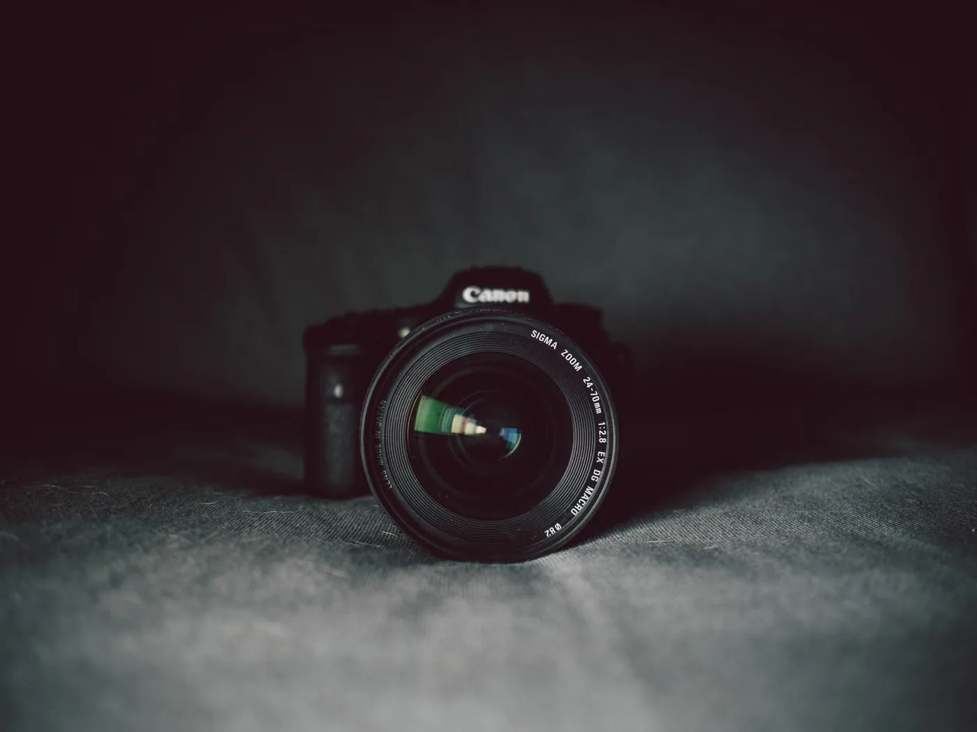 Koyu arka plan önünde fotoğraf makinesi ve objektif