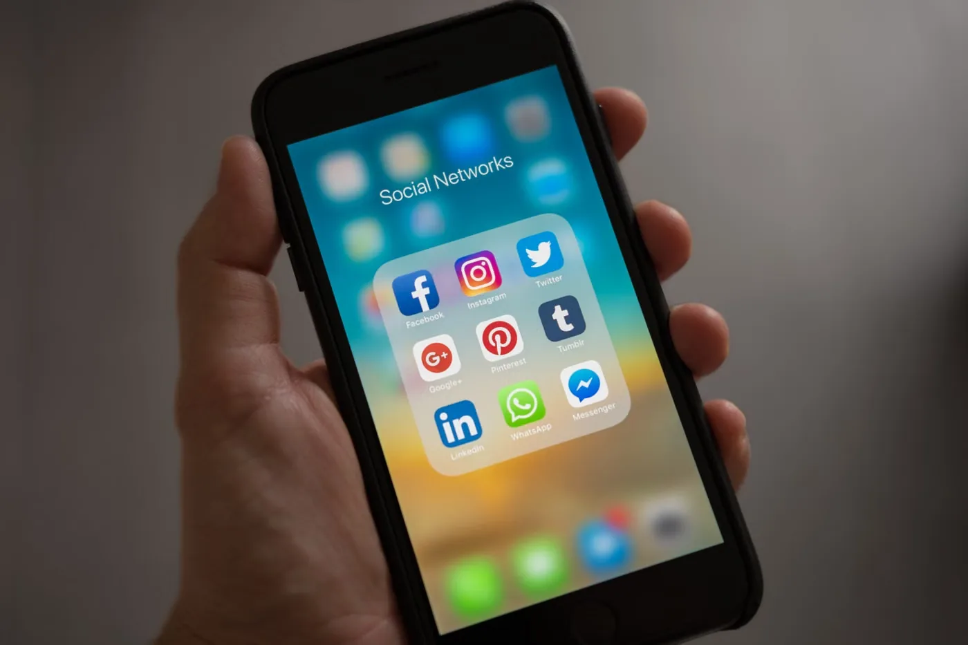 Sosyal ağ uygulamaları açık bir telefonu tutan el